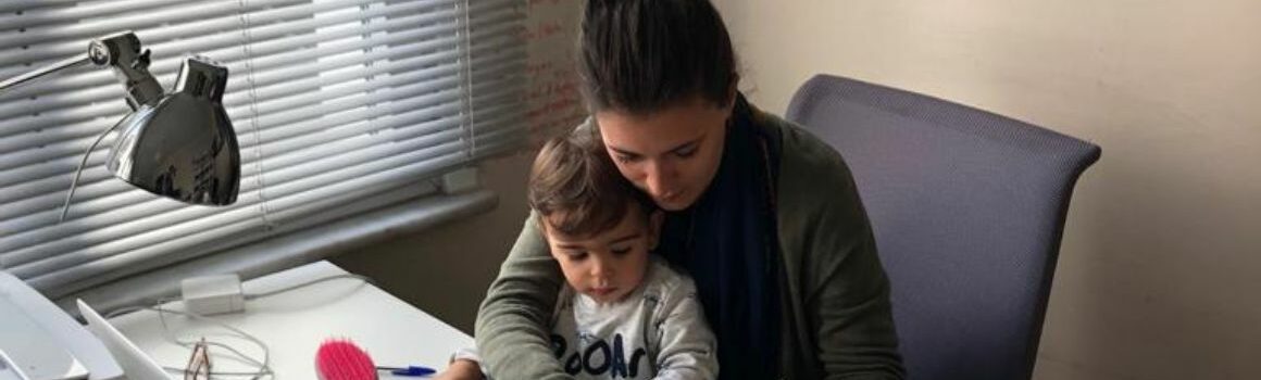 Mère entrepreneure en train de travailler avec son enfant sur les genoux